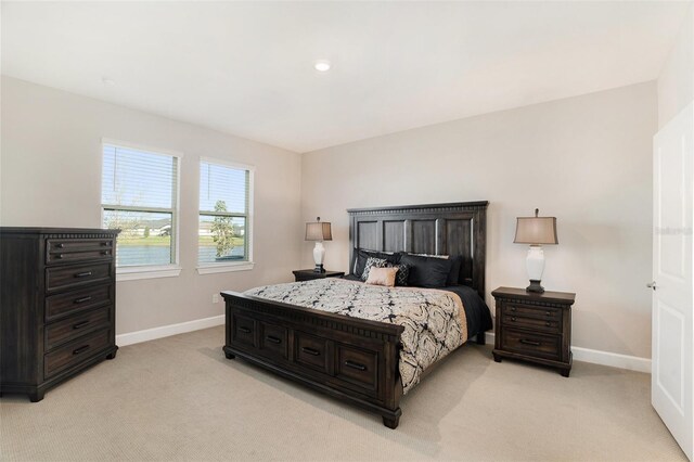 bedroom with baseboards and light colored carpet