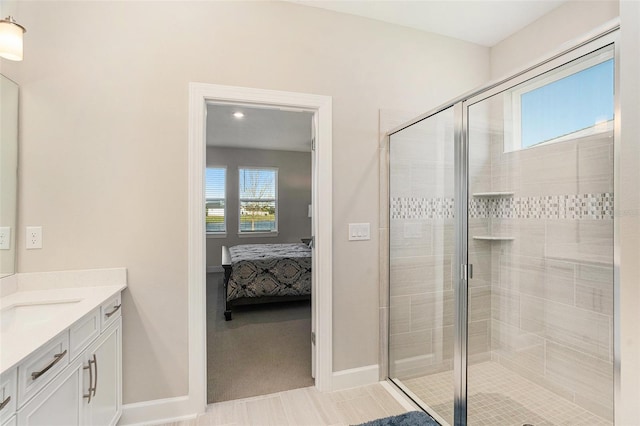 full bathroom featuring a stall shower, vanity, baseboards, and ensuite bathroom