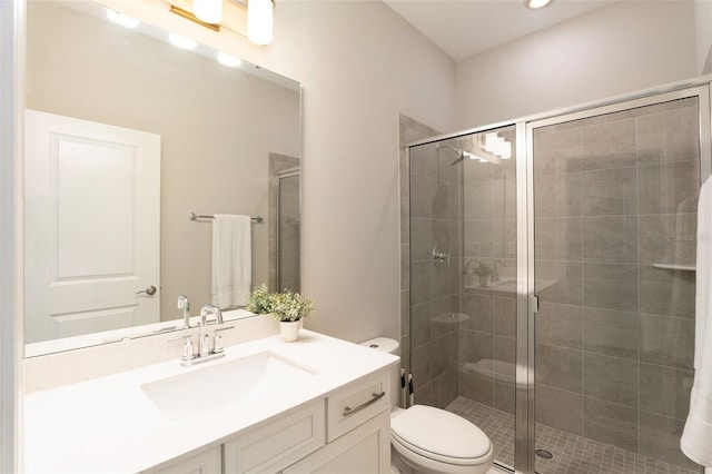 bathroom featuring toilet, a stall shower, and vanity