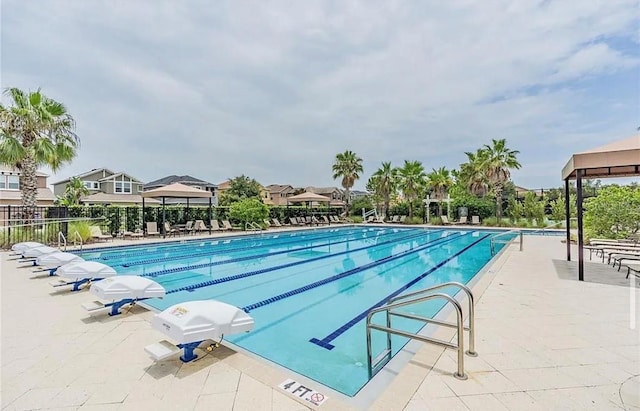 community pool with a patio and fence