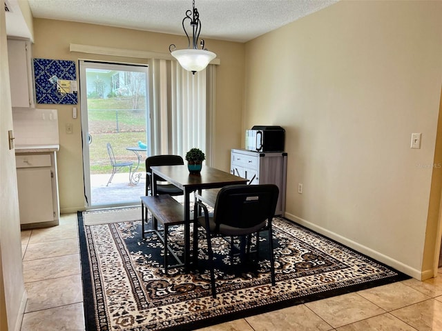 tiled dining area featuring a textured ceiling