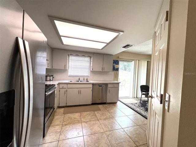 kitchen with a sink, light countertops, a healthy amount of sunlight, and stainless steel appliances