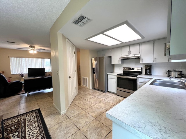 kitchen featuring ceiling fan, sink, stainless steel appliances, a textured ceiling, and light tile patterned floors