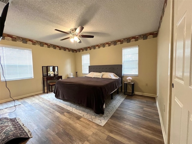 bedroom featuring ceiling fan, hardwood / wood-style floors, and a textured ceiling