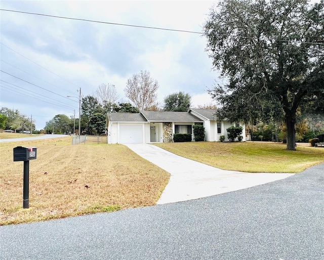 ranch-style house featuring a front lawn, an attached garage, and driveway