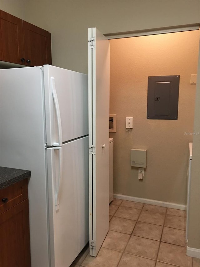 kitchen featuring electric panel, white fridge, and light tile patterned floors