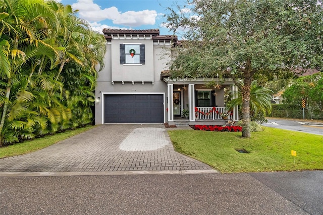 mediterranean / spanish house with a garage, a front lawn, and covered porch