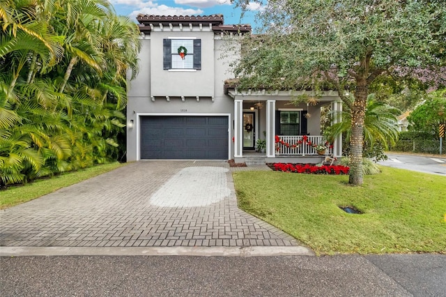 mediterranean / spanish-style house featuring a porch, a garage, and a front yard