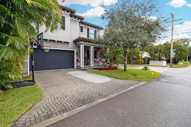 mediterranean / spanish-style house with a garage, a front yard, and a porch