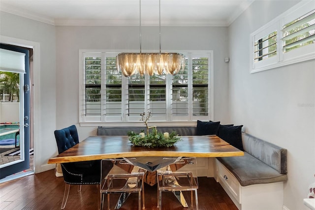 dining room featuring breakfast area, dark hardwood / wood-style flooring, ornamental molding, and an inviting chandelier