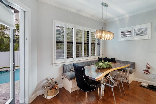 dining space featuring breakfast area, wood-type flooring, ornamental molding, and a chandelier