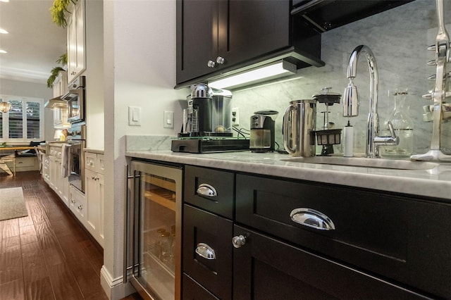 kitchen with white cabinetry, sink, backsplash, beverage cooler, and dark hardwood / wood-style flooring