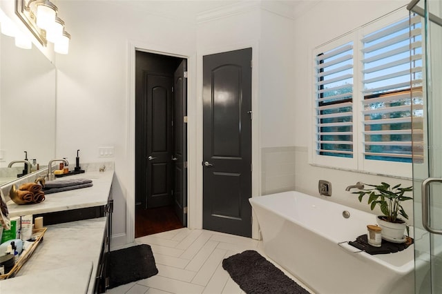 bathroom with vanity, crown molding, and a bathing tub