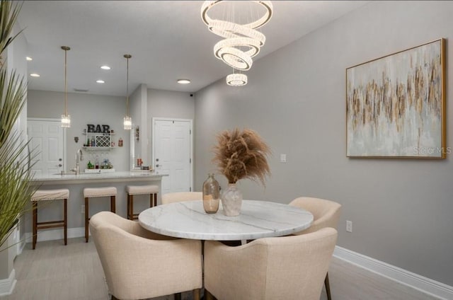 dining room featuring sink and a notable chandelier