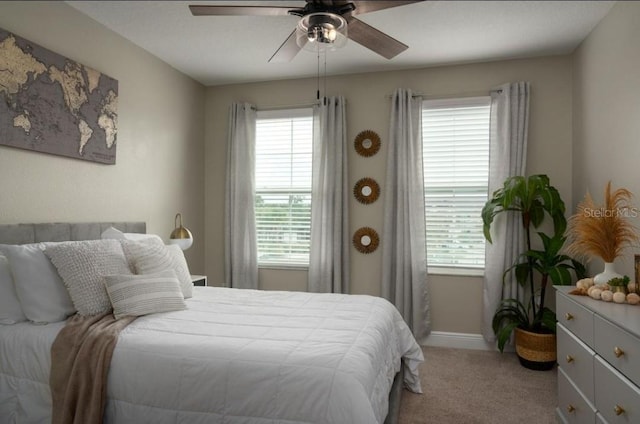 carpeted bedroom featuring multiple windows and ceiling fan