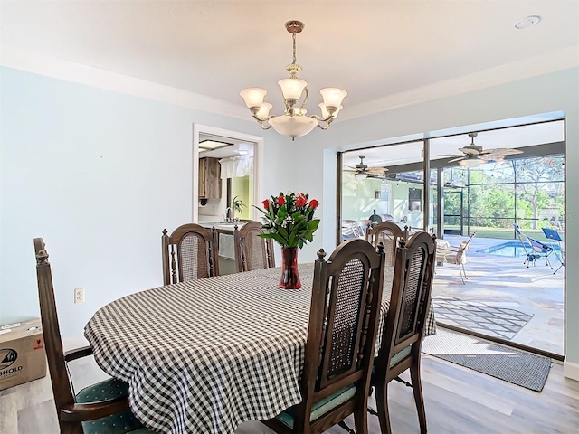 dining room featuring a notable chandelier, ornamental molding, and light hardwood / wood-style flooring