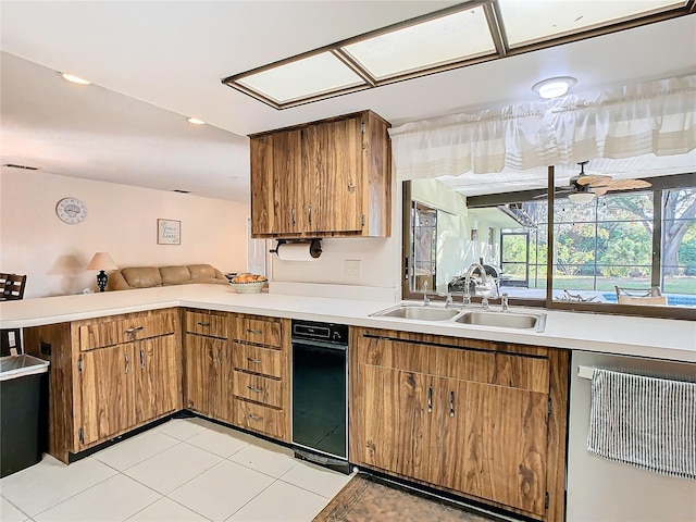 kitchen with dishwasher, sink, ceiling fan, light tile patterned floors, and kitchen peninsula