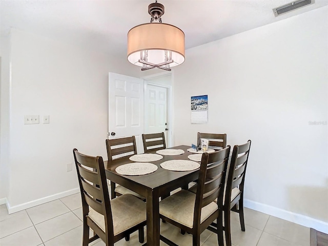 tiled dining room featuring a chandelier