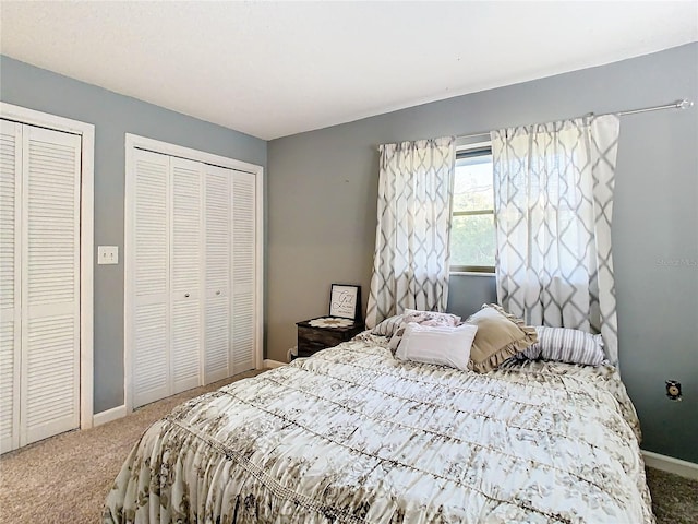 carpeted bedroom featuring two closets