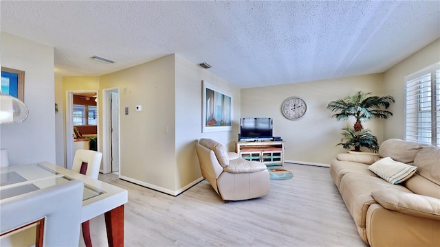 living room with light hardwood / wood-style floors and a textured ceiling