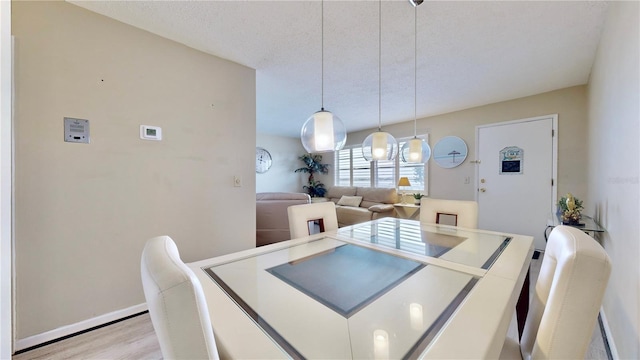 dining space featuring a textured ceiling and light hardwood / wood-style floors