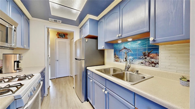 kitchen featuring backsplash, sink, stainless steel appliances, and blue cabinets