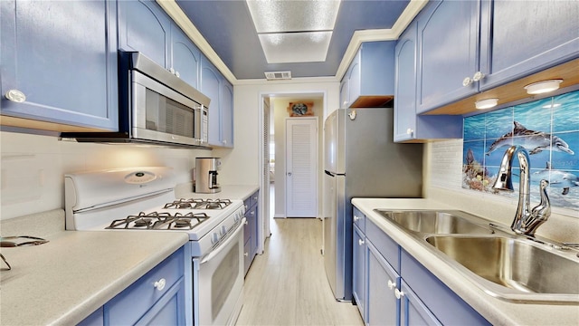 kitchen with appliances with stainless steel finishes, light hardwood / wood-style flooring, blue cabinets, and sink