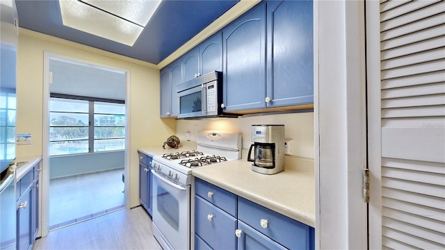 kitchen with blue cabinets, crown molding, and gas range gas stove