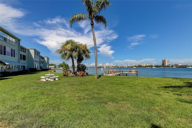 view of yard with a water view and a dock