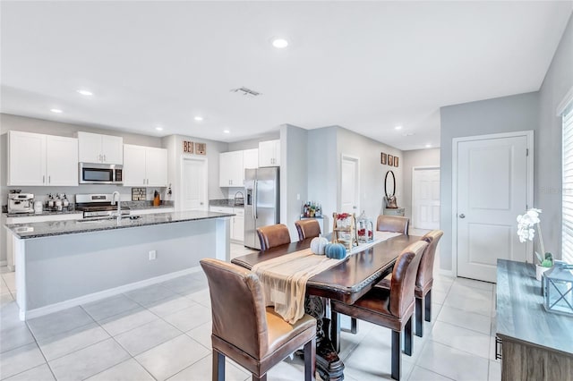 dining space with light tile patterned floors and sink