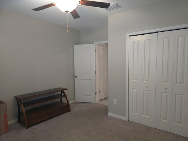 bedroom featuring a closet, ceiling fan, and light colored carpet