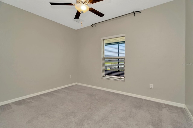 spare room with carpet, a ceiling fan, and baseboards