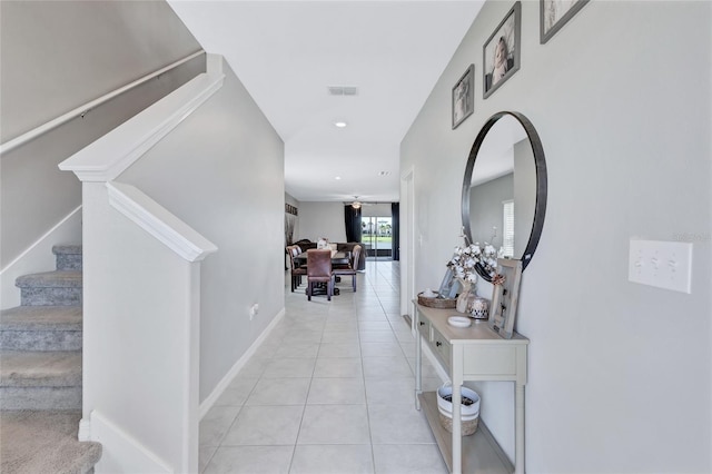 hallway featuring light tile patterned floors, recessed lighting, visible vents, stairway, and baseboards