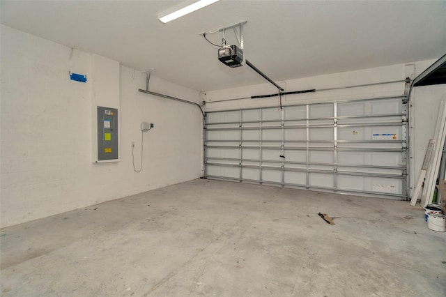 garage with a garage door opener, concrete block wall, and electric panel