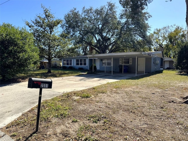 view of front of house with a carport and a front lawn