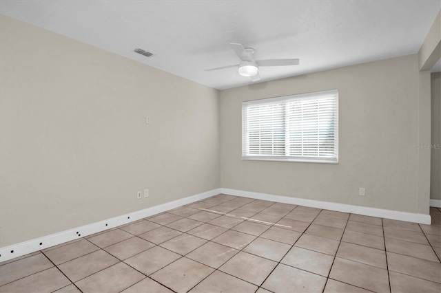 tiled spare room featuring ceiling fan