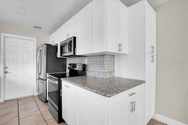 kitchen featuring white cabinetry, light tile patterned floors, light stone counters, and black range with electric cooktop