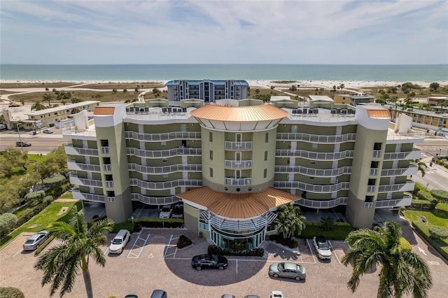 view of building exterior featuring a water view and a view of the beach