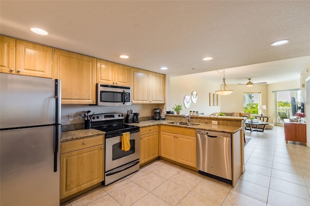 kitchen with light tile patterned floors, kitchen peninsula, and appliances with stainless steel finishes