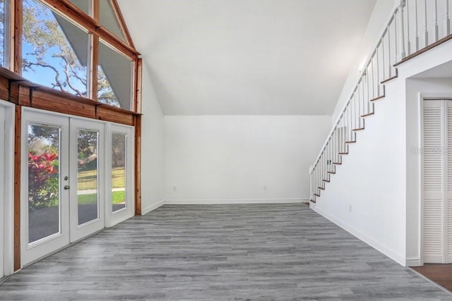 bonus room with french doors, high vaulted ceiling, and dark wood-type flooring