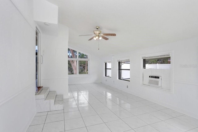 spare room featuring ceiling fan, cooling unit, lofted ceiling, and light tile patterned floors