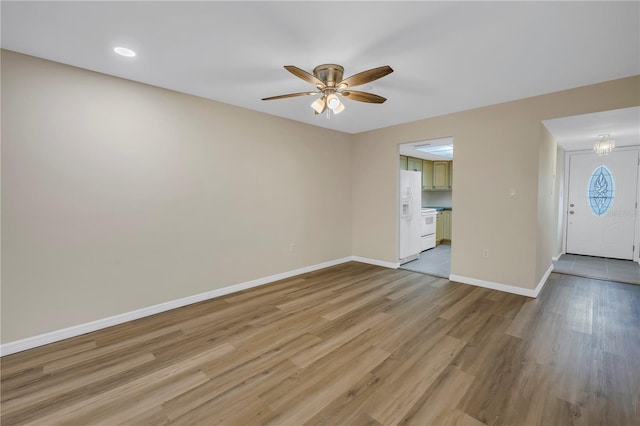 interior space featuring light wood-type flooring, baseboards, and a ceiling fan