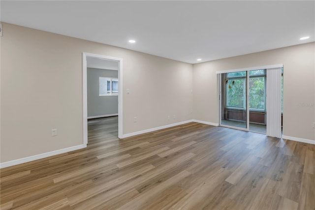 unfurnished room with baseboards, recessed lighting, and light wood-style floors