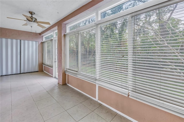 unfurnished sunroom with a ceiling fan