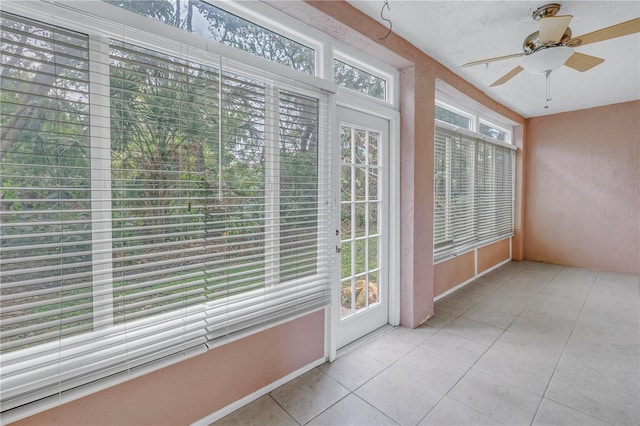 unfurnished sunroom featuring ceiling fan