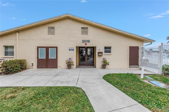 townhome / multi-family property featuring french doors, fence, and stucco siding