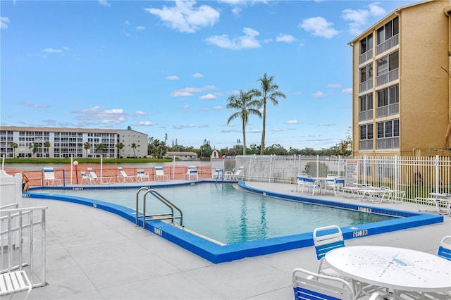 community pool with fence and a patio