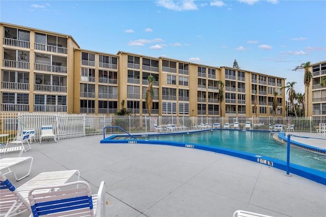 pool with a patio and fence