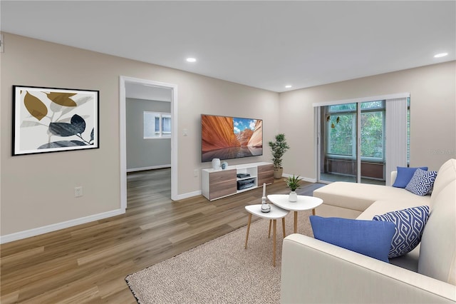 living room with recessed lighting, baseboards, and wood finished floors