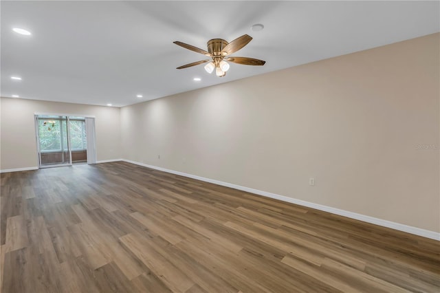 empty room featuring a ceiling fan, recessed lighting, baseboards, and wood finished floors